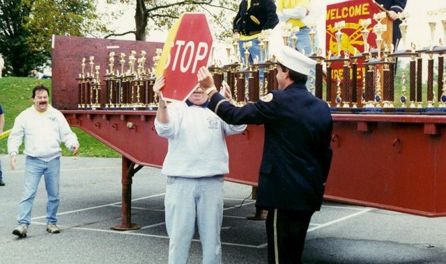 Steve Flegal gets the &quot;you hit a sign with the engine prize&quot; from Jeff Simpson at the 1998 Parade award ceremony.  Mike Predmore appears delighted.
